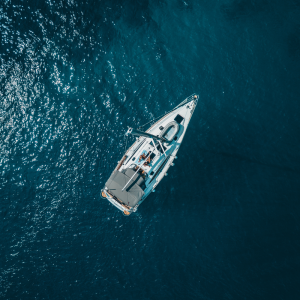 top view of a sailboat in the midde of a calm blue ocean - Image used for Web Design page